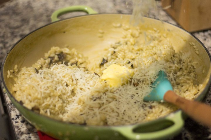 Adding butter and Parmesan cheese to the risotto